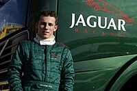 Christian Klien vor einem Renntransporter des Jaguar-Teams