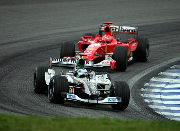 Titel-Bild zur News: Gianmaria Bruni (Minardi-Cosworth PS04B) vor Michael Schumacher (Ferrari F2004)