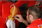 Ein Ferrari-Mechaniker montiert Sponsorenlogos