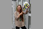 Jessica Michibate mit einem Sitzkissen in der Form und mit dem Design des Helmes ihres Freundes Jenson Button (Brawn) 