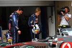 Mark Webber (Red Bull) und Sebastian Vettel (Red Bull) betrachten den McLaren