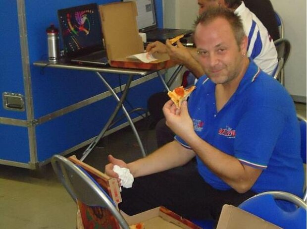 Superstars-Mechaniker beim Pizzaessen Superstars-Mechaniker beim Pizzaessen