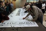 Fans signieren ein riesiges Dan-Wheldon-Banner