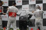 Jenson Button (McLaren) und Nico Rosberg (Mercedes)  nehmen Norbert Haug (Mercedes-Motorsportchef) in die Sektzange