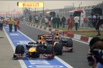 Sebastian Vettel (Red Bull) wird von Mark Webber (Red Bull) auf seine Position im Parc ferme geschoben