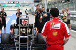Ferrari-Mechaniker schaut sich den Lotus E21 an
