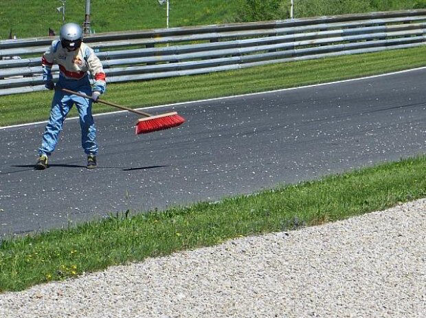 Auch fegen gehört dazu: Petra reinigt die Ideallinie am Salzburgring