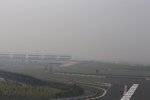 Kimi Räikkönen (Lotus) und Jules Bianchi (Marussia) im Smog von Noida