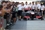 McLaren-Mechaniker schieben das Auto durch die Boxengasse
