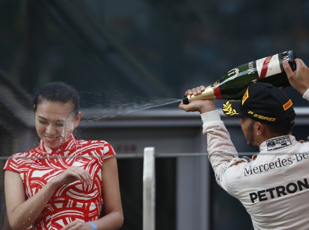 Lewis Hamilton spritzt beim China Grand Prix 2015 Champagner auf ein Grid Girl
