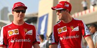 Bild zum Inhalt: Sebastian Vettel und Kimi Räikkönen flachsen über Gridgirls