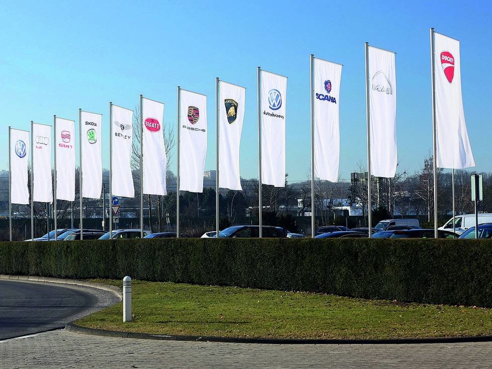 Fahnen der Konzernmarken vor dem Verwaltungshochhaus am VW-Stammsitz Wolfsburg