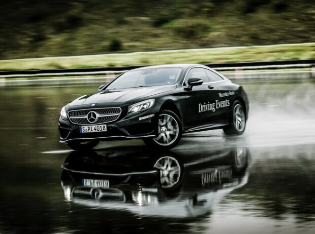 Schlitternd über eine nasse Fahrbahn: So könnte das exklusive Mercedes-Fahrertraining mit einem DTM-Profi für Zwei aussehen
