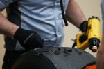 Pirelli-Mechaniker schaben Gummi von den Laufflächen und verwenden dafür eine Hitzepistole