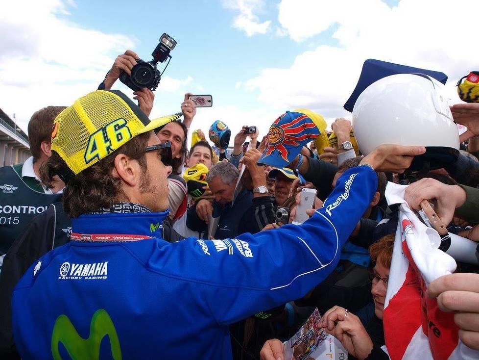 Valentino Rossi schreibt Autogramme umringt von seinen Fans