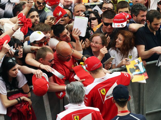 Kimi Räikkönen schreibt Autogramme für seine Fans