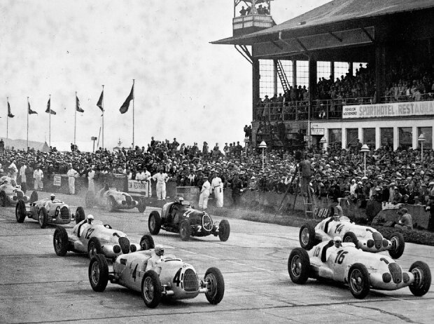 Großer Preis von Deutschland auf dem Nürburgring, 25. Juli 1937, kurz nach dem Start. Rudolf Caracciola auf Mercedes-Benz Rennwagen W 125 (Startnummer 12) gewinnt das Rennen vor seinem Mannschaftskameraden Manfred von Brauchitsch (Startnummer 14)