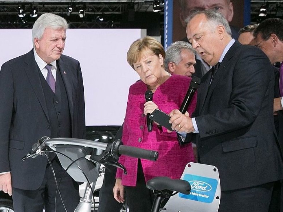 IAA-Rundgang der Kanzlerin (v.r.): Gunnar Herrmann, Vorsitzender der Geschäftsführung der Kölner Ford-Werke, erläutert Angela Merkel und Hessens Ministerpräsident Volker Bouffier das Car- und Bikesharingangebot