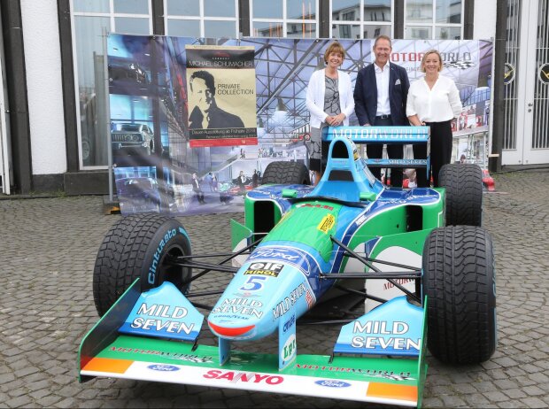 Titel-Bild zur News: Henriette Reker, Andreas Dünkel, Sabine Kehm hinter Schumi-Benetton Ford
