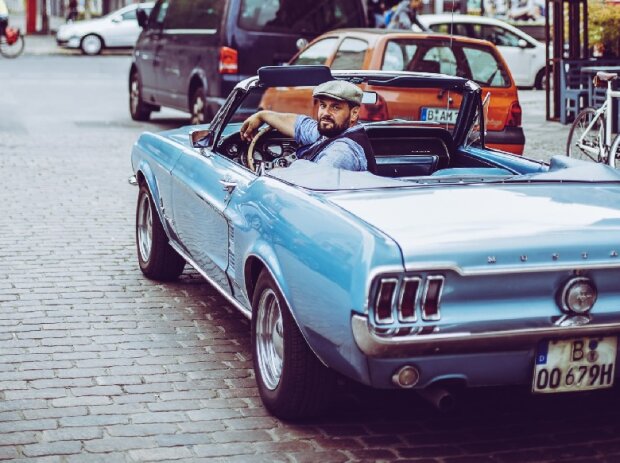 Titel-Bild zur News: Ulf Schulz, Organisator der Motorworld Classics Berlin, im Ford Mustang