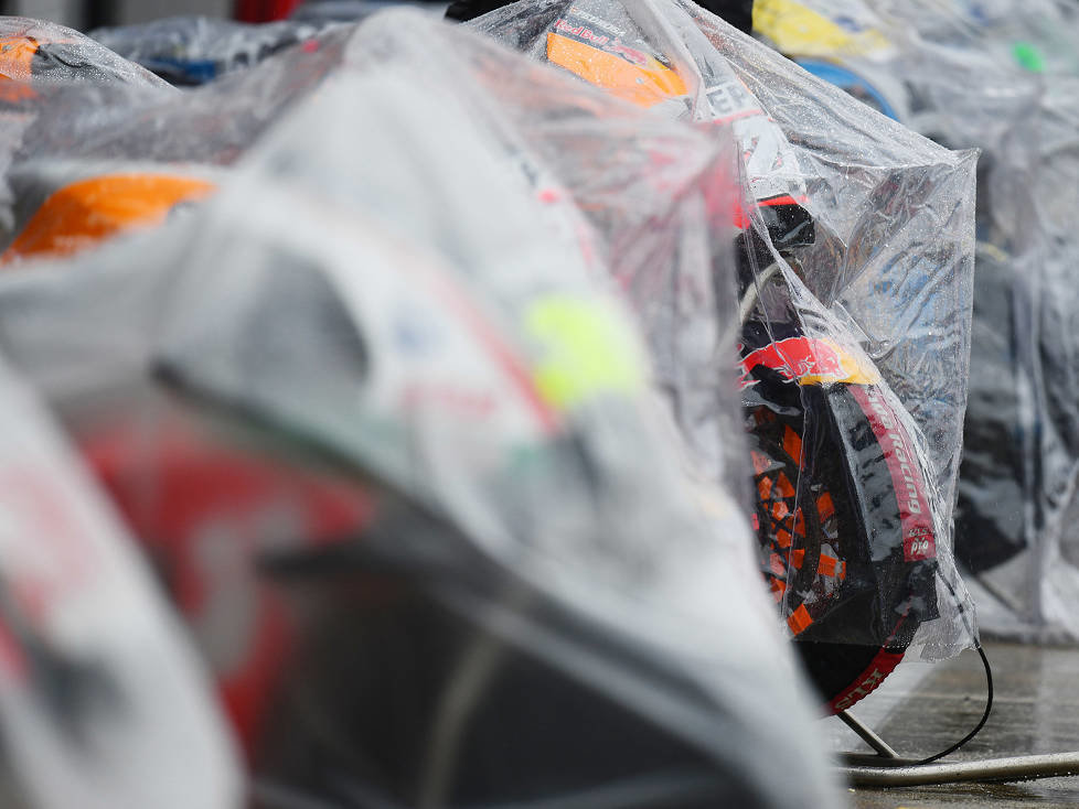 MotoGP-Bikes unter Regenplanen