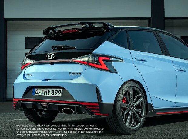 Dreiviertelansicht des Hecks und der rechten Seitenansicht des Hyundai i20 N 2020, der vor den Garagen einer Boxengasse steht Dreiviertelansicht des Hecks und der rechten Seitenansicht des Hyundai i20 N 2020, der vor den Garagen einer Boxengasse steht