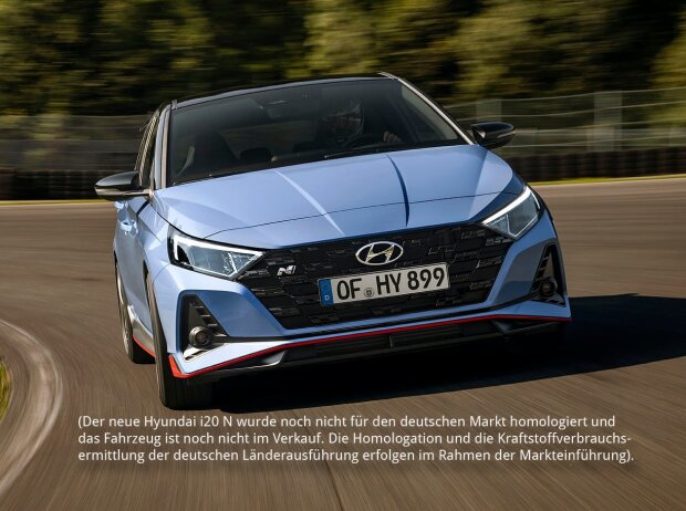 Frontansicht des Hyundai i20 N 2020, der sich schnell in einer Kurve auf einer Rennstrecke bewegt Frontansicht des Hyundai i20 N 2020, der sich schnell in einer Kurve auf einer Rennstrecke bewegt