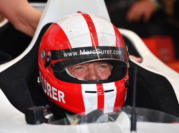 Marc Surer mit Helm in einem Rennwagen