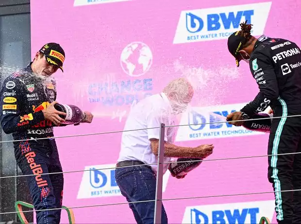Max Verstappen (Red Bull) und Lewis Hamilton (Mercedes) bespritzen Helmut Marko (Red Bull) bei der Siegerehrung zum Grand Prix der Steiermark auf dem Red-Bull-Ring in Spielberg (Österreich) 2021 mit Schaumwein der Marke Ferrari Trento Titel-Bild zur News: Max Verstappen (Red Bull) und Lewis Hamilton (Mercedes) bespritzen Helmut Marko (Red Bull) bei der Siegerehrung zum Grand Prix der Steiermark auf dem Red-Bull-Ring in Spielberg (Österreich) 2021 mit Schaumwein der Marke Ferrari Trento