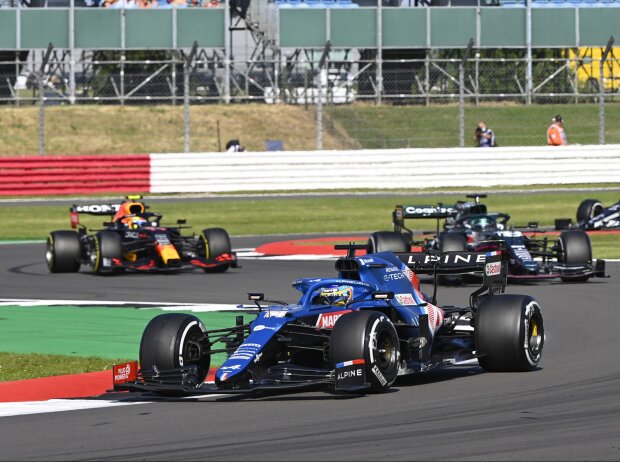 Fernando Alonso im Alpine A521 im Grand Prix von Großbritannien der Formel 1 2021 in Silverstone in England vor Lance Stroll im Aston Martin AMR21 und Sergio Perez im Red Bull RB16B