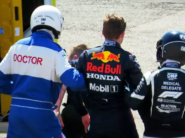 Max Verstappen (Red Bull) wird nach seinem Unfall mit Lewis Hamilton (Mercedes) von den Ärzten gestützt Titel-Bild zur News: Max Verstappen (Red Bull) wird nach seinem Unfall mit Lewis Hamilton (Mercedes) von den Ärzten gestützt