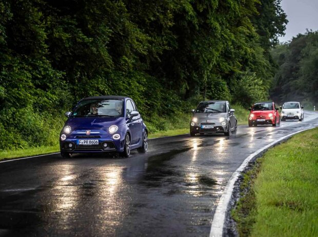 Mehrere Abarth auf einer nassen Landstraße Mehrere Abarth auf einer nassen Landstraße