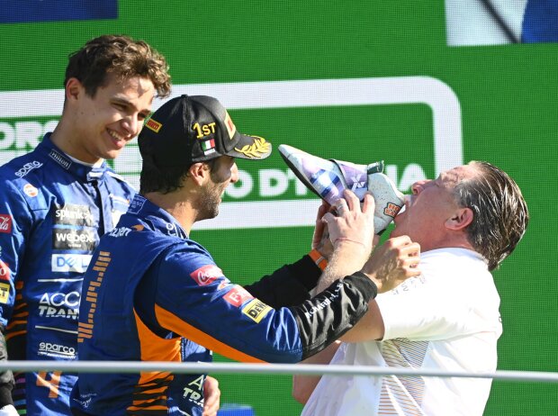 Titel-Bild zur News: Daniel Ricciardo, Lando Norris & McLaren-Geschäftsführer Zak Brown feiern mit einem Shoey auf dem Podium in Monza