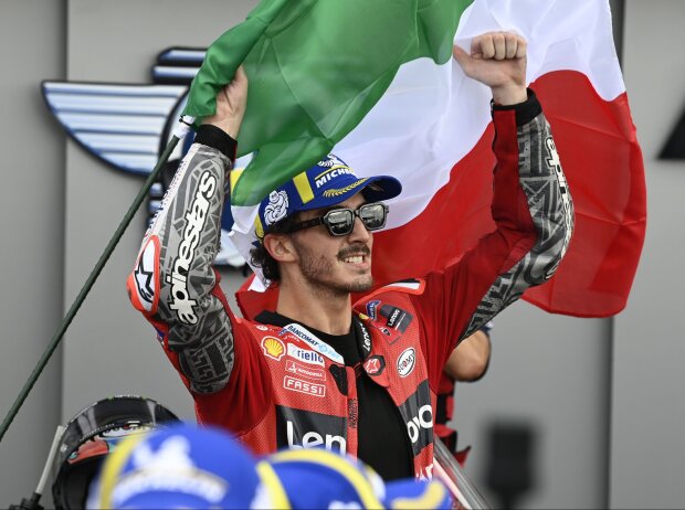 Francesco Bagnaia mit der italienischen Flagge nach seinem MotoGP-Sieg in Misano. Francesco Bagnaia mit der italienischen Flagge nach seinem MotoGP-Sieg in Misano.