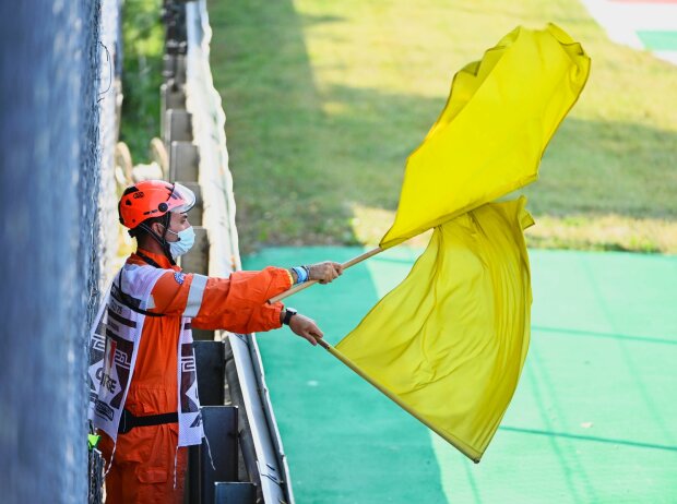Titel-Bild zur News: Ein Formel-1-Marshall schwenkt doppelt gelbe Flaggen