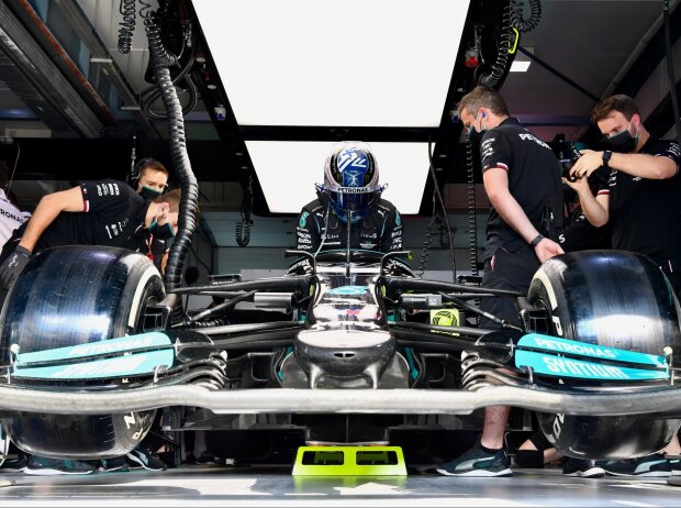 Valtteri Bottas im Mercedes W12 und Mercedes-Mechaniker in der Box in Katar 2021