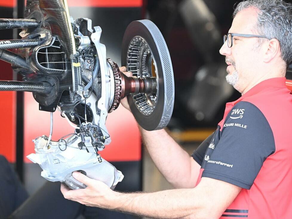 Mechaniker mit Bremsscheibe an der Vorderachse des Ferrari F1-75 in der Formel 1 2022