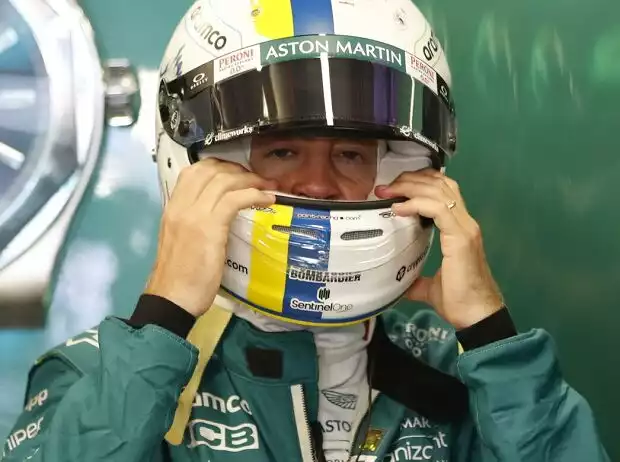 Sebastian Vettel zieht sich in der Box von Aston Martin den Helm an Titel-Bild zur News: Sebastian Vettel zieht sich in der Box von Aston Martin den Helm an