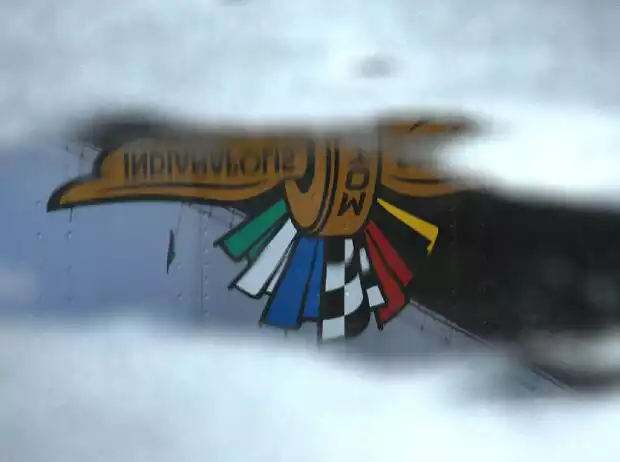Logo des Indianapolis Motor Speedway als Reflexion in einer Regenpfütze Titel-Bild zur News: Logo des Indianapolis Motor Speedway als Reflexion in einer Regenpfütze