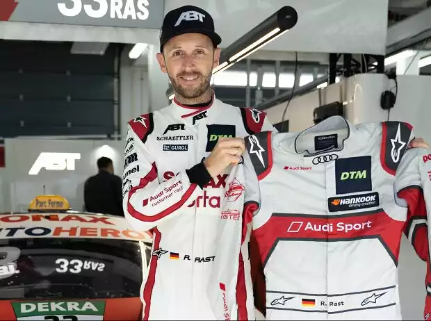 Rene Rast mit seinem Meister-Rennoverall aus dem Jahr 2019 Titel-Bild zur News: Rene Rast mit seinem Meister-Rennoverall aus dem Jahr 2019