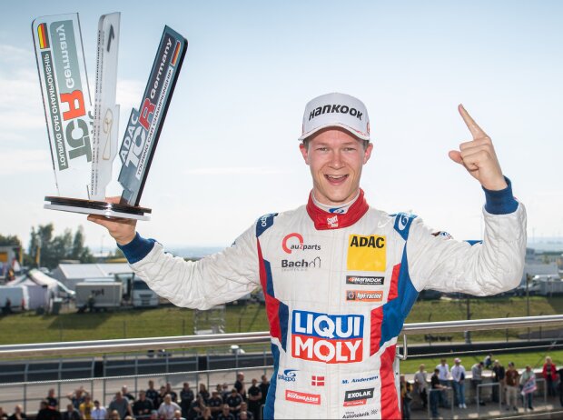 Martin Andersen präsentiert die Trophäe für den Sieg im Sonntagsrennen der ADAC TCR Germany auf dem Sachsenring