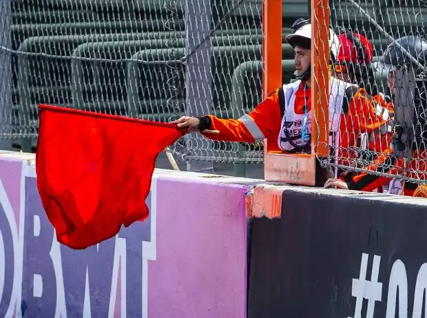 Ein Streckenposten hält eine rote Flagge Titel-Bild zur News: Ein Streckenposten hält eine rote Flagge