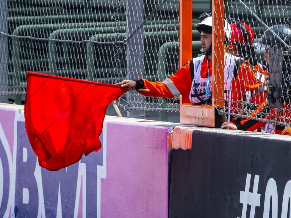 Ein Streckenposten hält eine rote Flagge