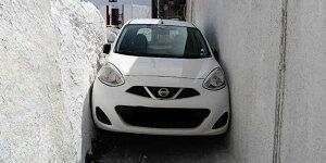 Nissan Micra bleibt stecken, als Tourist in enge Gasse abbiegt