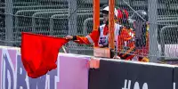 Ein Sportwart hält die rote Flagge bei einem Formel-1-Rennen