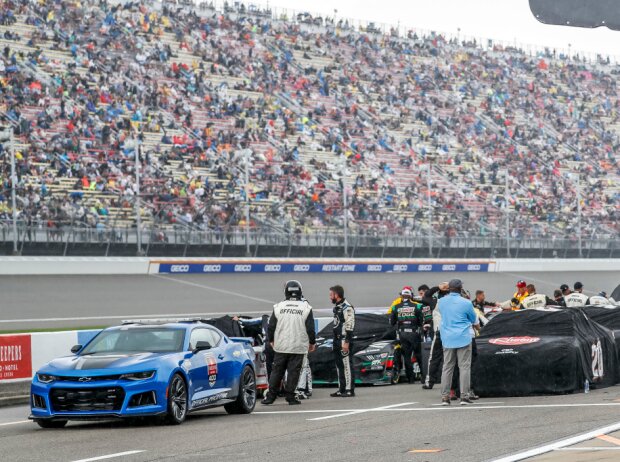 Titel-Bild zur News: NASCAR-Autos unter Regenplanen in der Boxengasse des Michigan International Speedway