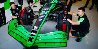 Mechaniker mit Reifenheizdecken am Formel-1-Auto von Guanyu Zhou 2024