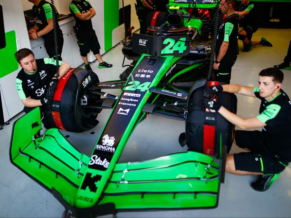Mechaniker mit Reifenheizdecken am Formel-1-Auto von Guanyu Zhou 2024