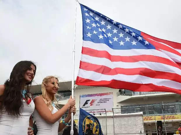 Zwei Frauen posieren mit der US-Flagge in der Formel-1-Startaufstellung Titel-Bild zur News: Zwei Frauen posieren mit der US-Flagge in der Formel-1-Startaufstellung