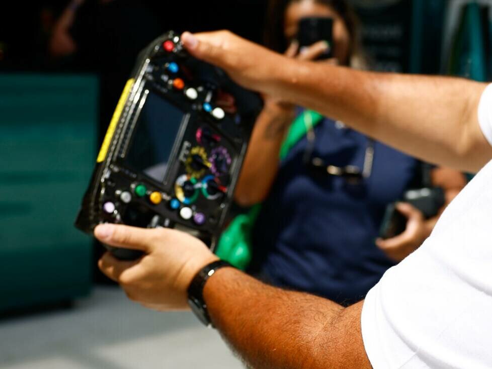 Symbolbild: Formel-1-Fan mit Lenkrad im Fahrerlager